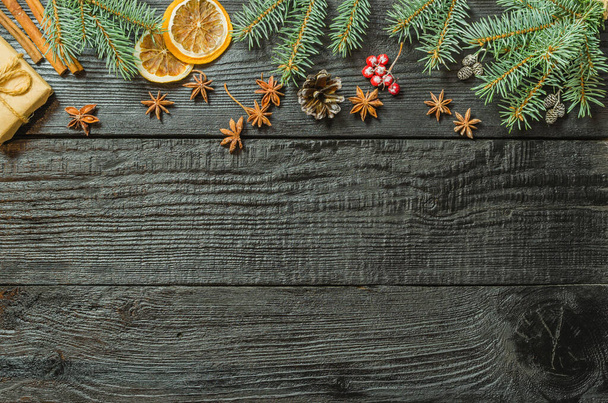 Christmas fir tree branches and pine cones on wooden dark, black background. - Foto, Imagen