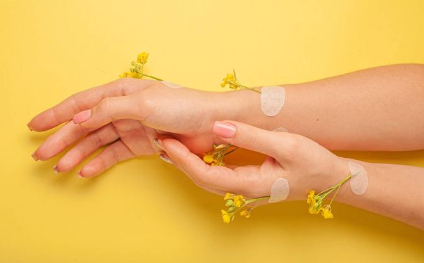 Hands art flower natural cosmetics women, yellow beautiful, spring flowers hand with bright contrast makeup, hand care. Fashion, creative beauty photo girl sitting at table,  yellow contrasting background.View from above, closeup. - Φωτογραφία, εικόνα