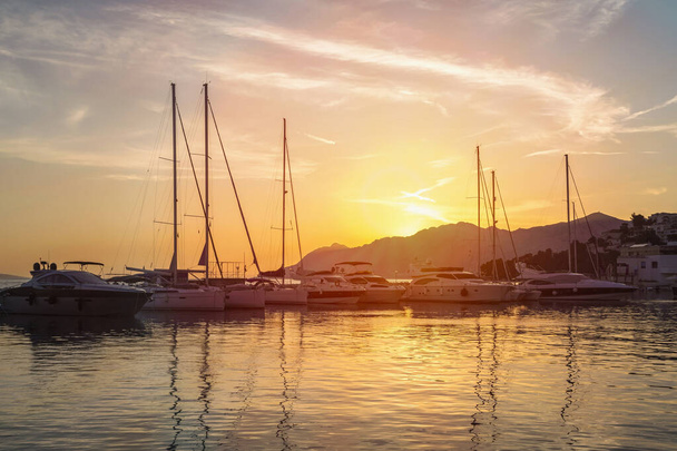 Pôr do sol em Baska Voda cidade com mar Adriático e barcos, Croácia
 - Foto, Imagem