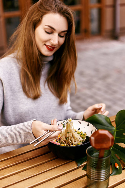 Young european girl eating ramen - Фото, изображение