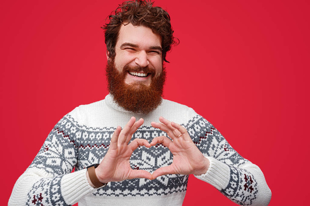 Cheerful male in sweater gesturing heart - Photo, Image