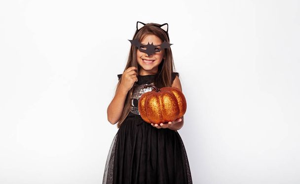 Happy girl with bat mask and shiny pumpkin - Foto, immagini