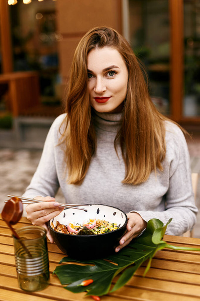 Young european girl eating ramen - 写真・画像