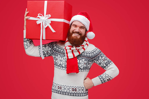 Cheerful Santa delivering Christmas present - Фото, изображение