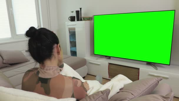 Kobieta ogląda zielony ekran 4k płaski telewizor w autokarze W domu - Materiał filmowy, wideo