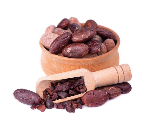 Geschälte Kakaobohnen in der Holzschale, isoliert auf weißem Hintergrund. geröstete und aromatische Kakaobohnen im Holzlöffel, natürliche Schokolade. - Foto, Bild