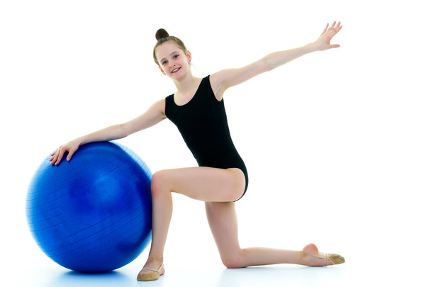 little girl doing exercises on a big ball for fitness. - Zdjęcie, obraz