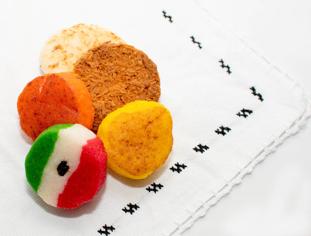 典型的なメキシコのココナッツキャンディーの束とバスケットハニーコカダ伝統的なメキシコの国旗カーペットの背景孤立した色サラペメキシコ - 写真・画像
