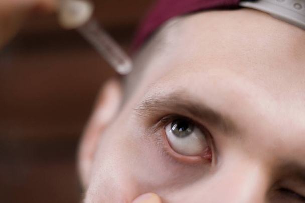 close up man drop some medicine eye drops, treatment process - Foto, afbeelding
