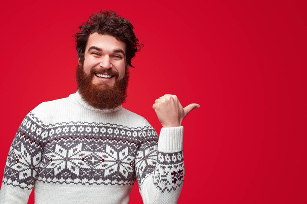 Cheerful bearded guy pointing aside - Photo, Image