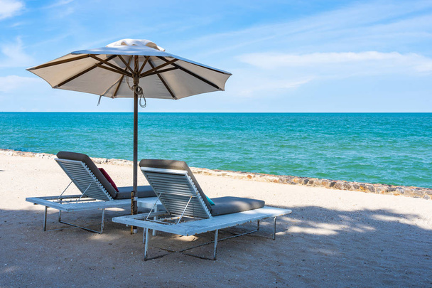 Mooie paraplu en stoel rond strand zee oceaan met blauwe SK - Foto, afbeelding