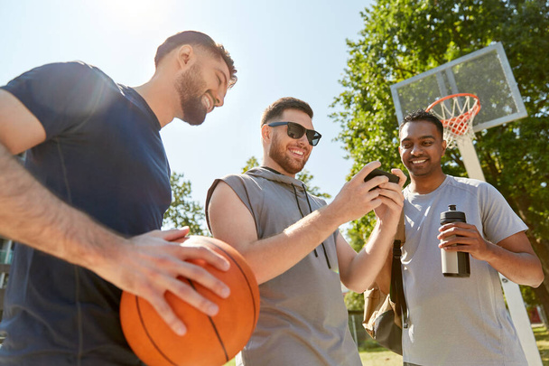 men with smartphone on basketball playground - Zdjęcie, obraz