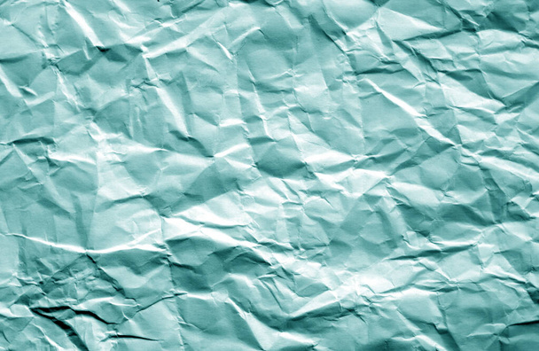 Crumpled sheet of paper with blur effect in cyan color. - Photo, Image