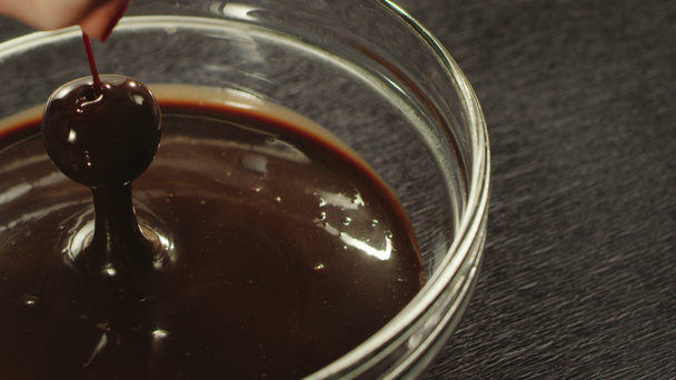 Primer plano mano sumergiendo cereza en chocolate caliente en cámara lenta
 - Imágenes, Vídeo