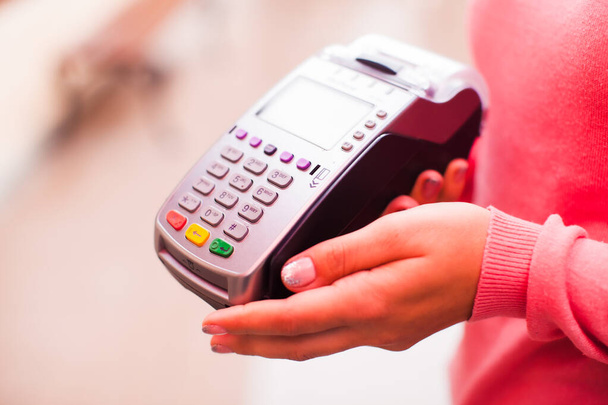Woman holds wi-fi compact payments terminal, close up hands - Valokuva, kuva