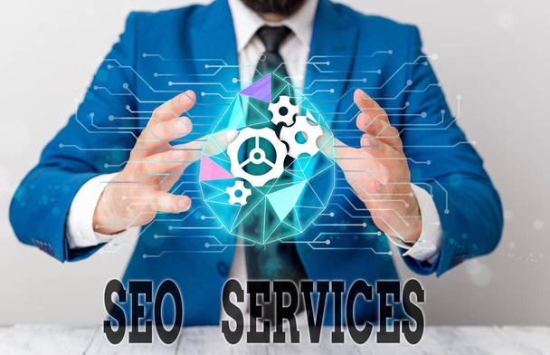 Handwriting text Seo Services. Concept meaning suite of techniques and procedures to surge website visibility Male human wear formal work suit presenting presentation using smart device. - 写真・画像