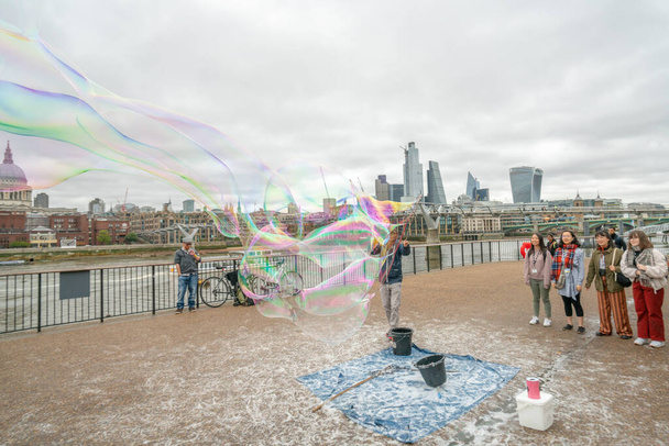 Londen, Verenigd Koninkrijk - oktober 2019: Grote zeepbellen show - straatartiesten vermaken toeristen - Foto, afbeelding
