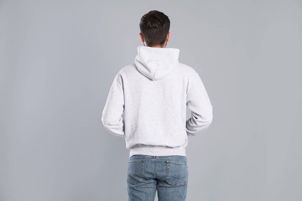 Young man in sweater on grey background. Mock up for design - 写真・画像