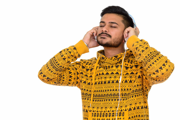 Young handsome Indian man listening to music - Foto, Imagem