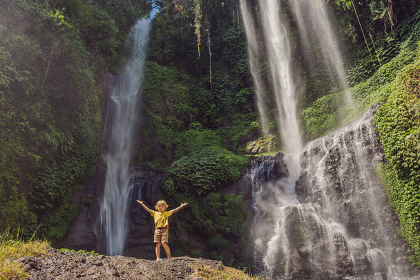 Boy at the Sekumpul waterfalls in jungles on Bali island, Indonesia. Bali Travel Concept - Zdjęcie, obraz