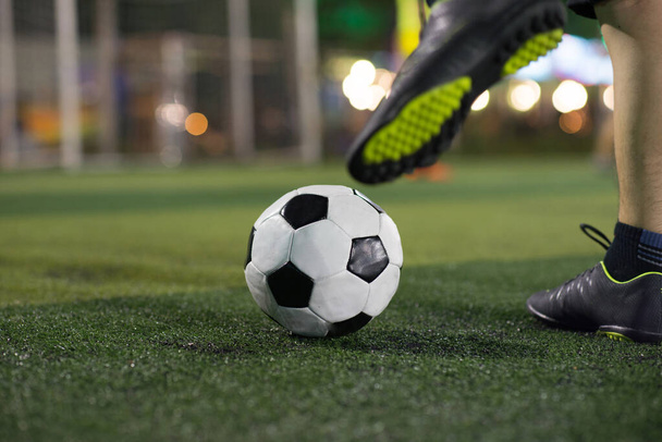 Fotbalista noha kopající míč na fotbalovém hřišti  - Fotografie, Obrázek
