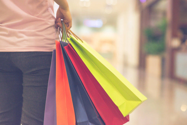 Close up photo of woman hand holding colorful shopping bags - Zdjęcie, obraz