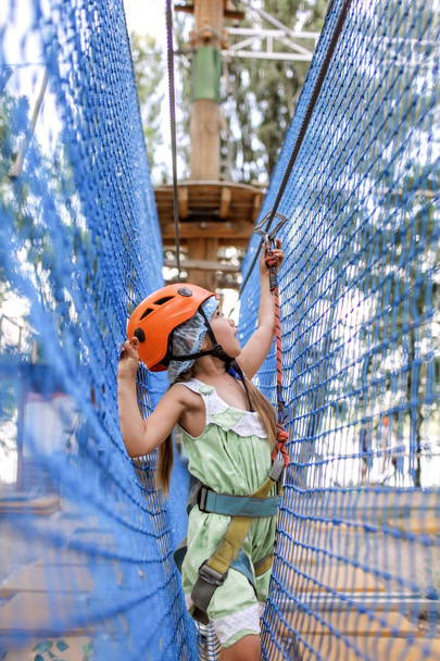 Girl enjoying time in a rope structure at adventure park - Foto, Bild