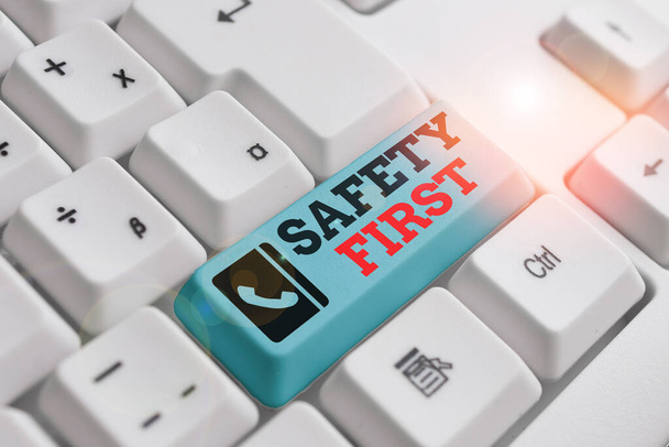 Text sign showing Safety First. Conceptual photo said to mean that it is best to avoid any unnecessary risks White pc keyboard with empty note paper above white background key copy space. - Photo, Image