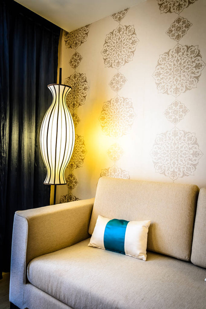 bela sala de estar com elementos de design peranakan e sofás e mesas de café e lâmpadas
 - Foto, Imagem