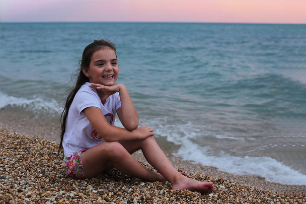 Tuhma tyttö viettää kesälomaa meren rannalla
 - Valokuva, kuva