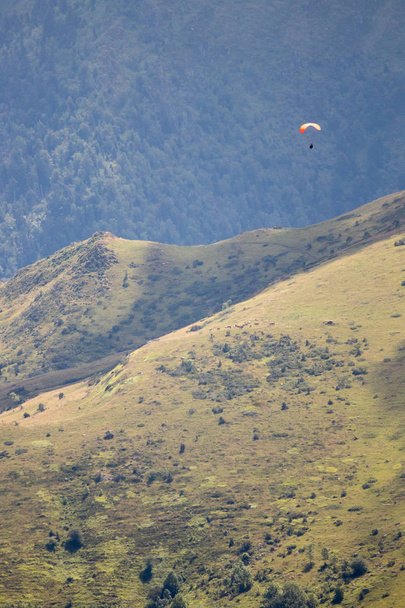 людина з парапланом літає серед гір
 - Фото, зображення