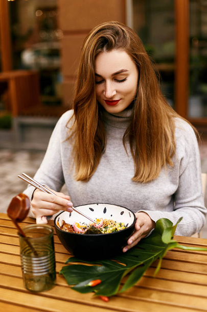 Young european girl eating ramen - Foto, afbeelding