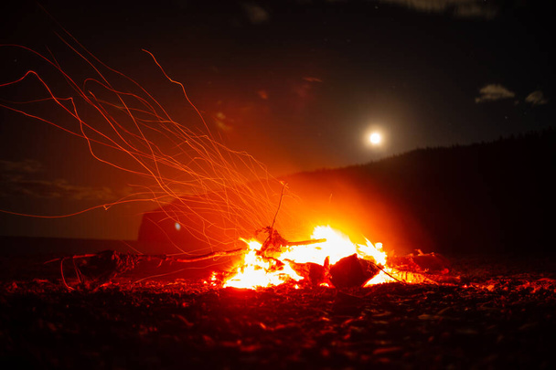Lagerfeuer bei Sonnenuntergang auf dem Campingplatz auf der Insel Anticosti, Quebec, Kanada - Foto, Bild