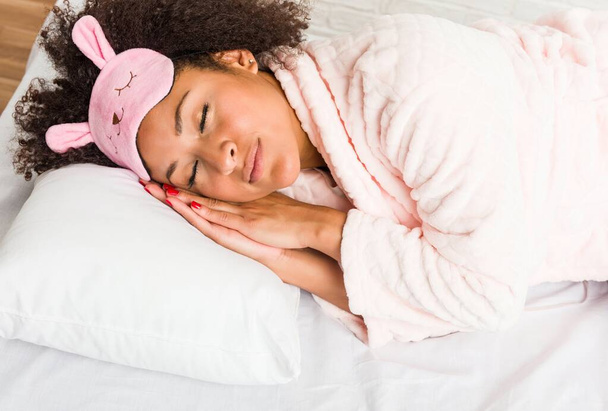 Mladá Africká Američanka spí s polštářem na posteli - Fotografie, Obrázek