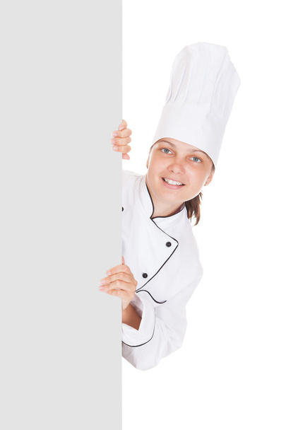 Female chef pointing on blank placard - Zdjęcie, obraz