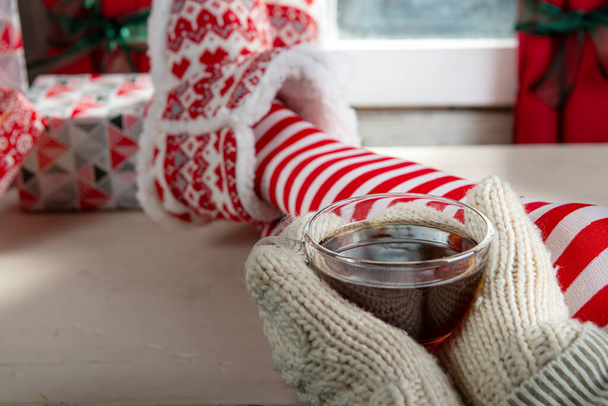Chica en calcetines disfrutando de un invierno bebiendo taza de té
 - Foto, Imagen