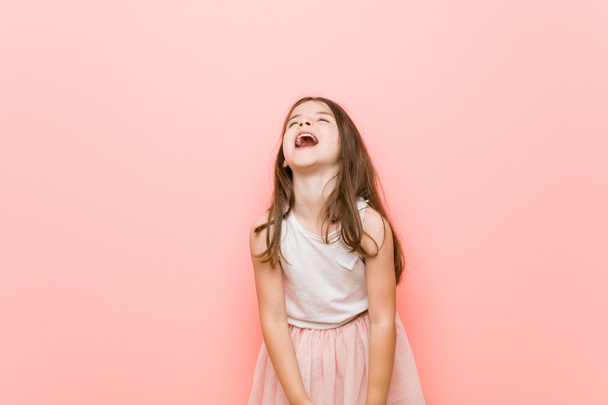 Little girl wearing a princess look relaxed and happy laughing, neck stretched showing teeth. - Foto, immagini