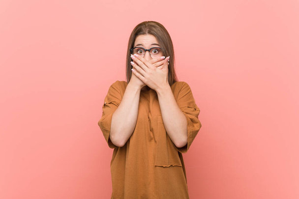 Young student woman wearing eyeglasses shocked covering mouth with hands. - Photo, Image