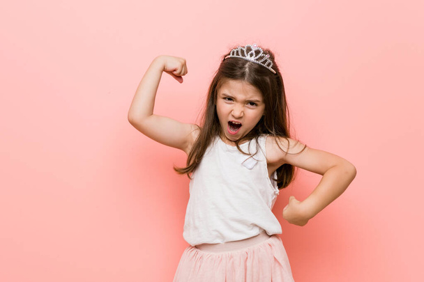 Menina vestindo uma princesa olhar levantando punho depois de uma vitória, conceito vencedor
. - Foto, Imagem