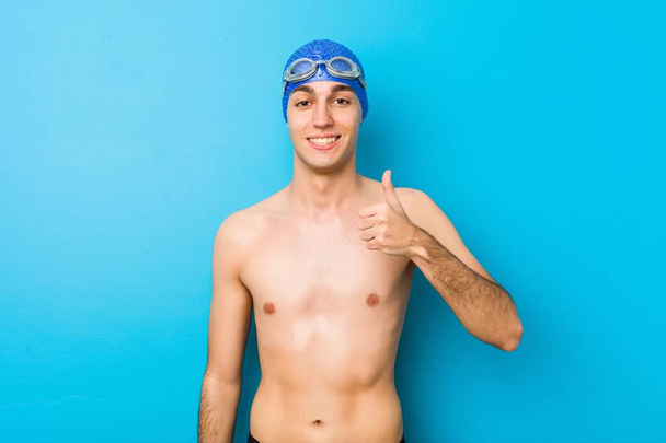 Young swimmer man smiling and raising thumb up - Fotoğraf, Görsel