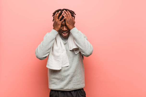 Молодий фітнес африканський чорний чоловік покриває очі руками, посміхається широко чекаючи сюрпризу
. - Фото, зображення