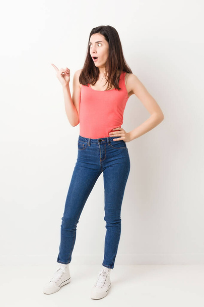 Full body young woman on white background pointing to the side - Фото, изображение
