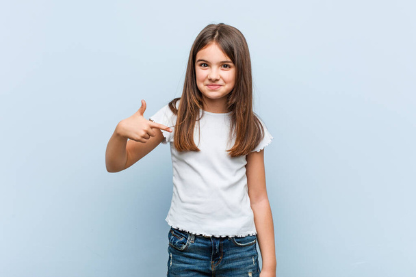 Cute girl person pointing by hand to a shirt copy space, proud and confident - Foto, Bild