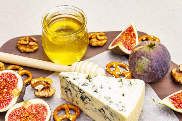 Assiette au fromage (planche) avec fromage bleu, miel, noix, figues, bretzels
 - Photo, image