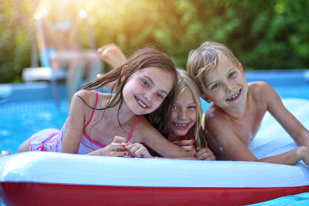 kids have fun in the pool on a hot day - Foto, Imagen