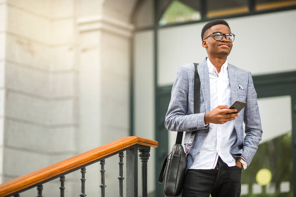 handsome young african man in a suit with a phone in his hand - Photo, image