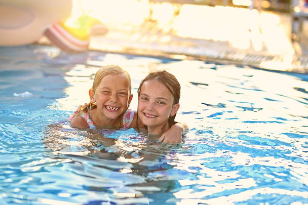 Друзі в басейні розважаються в сонячний день
 - Фото, зображення