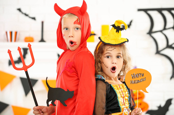 Young girl and boy in costumes holding paper cat and text Happy  - 写真・画像