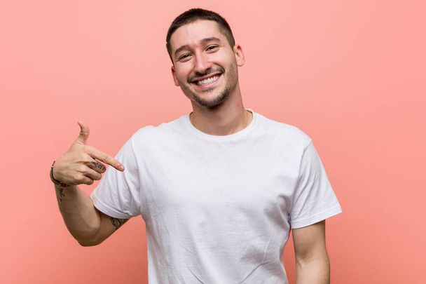 Fiatal alkalmi férfi személy mutató kézzel egy ing fénymásoló tér, büszke és magabiztos - Fotó, kép