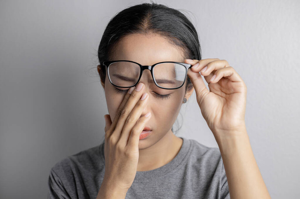 Women hold glasses and suffer from eye pain. - Photo, Image